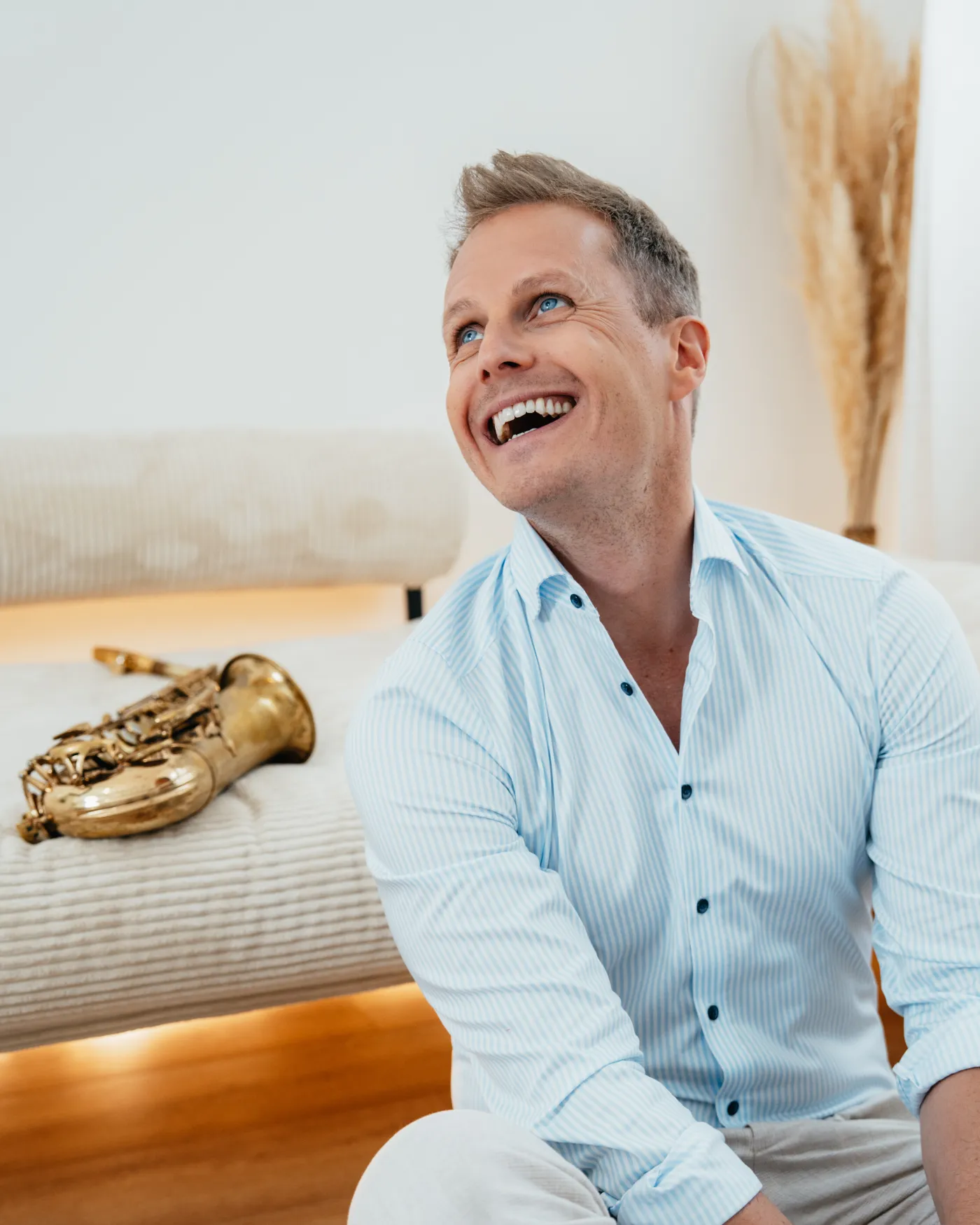 Saxophonist Philipp Schoof lacht, neben ihm sein Saxophon